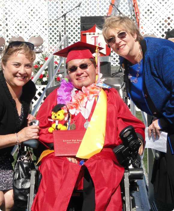 RCC team members pose next to a recent graduate