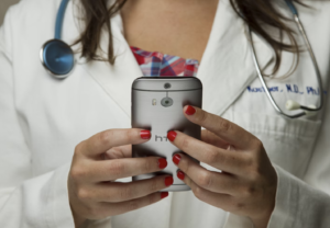 A Doctor looks down at her device for a telemedicine chat