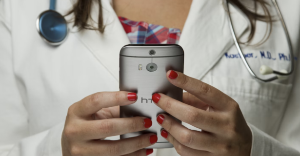 A Doctor looks down at her device for a telemedicine chat